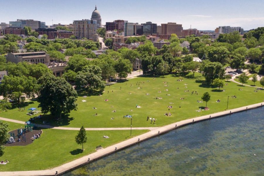 Picture of James Madison Park from Lake Mendota, featuring a green lawn, trees, and the capitol in the background