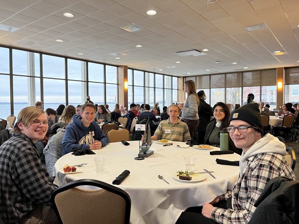 A table with smiling undergraduate students