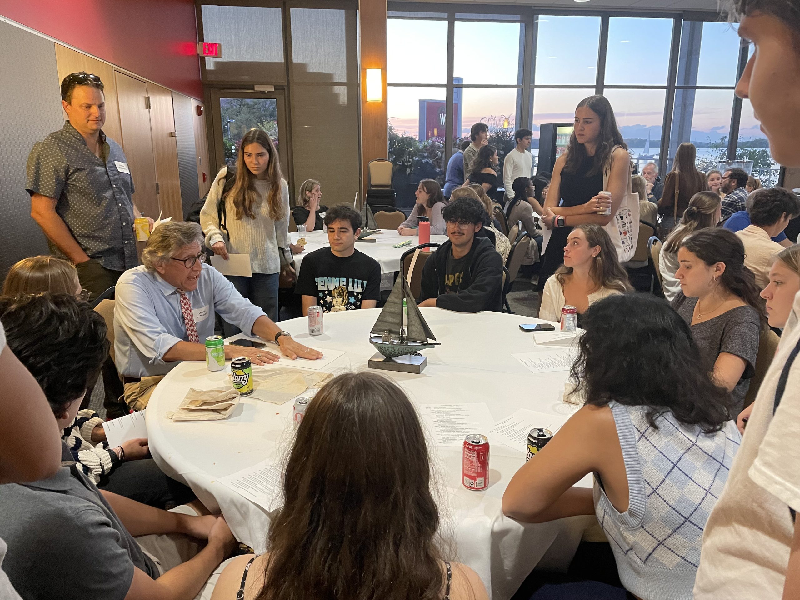Students gather around a faculty member who shares information about their research. 
